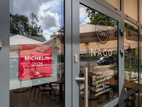 Wejście do restauracji NAGO z naklejką MICHELIN 2026 na szybie