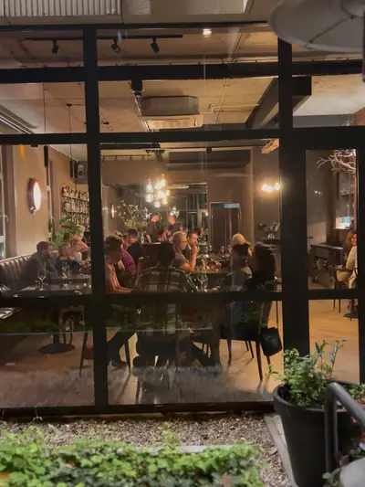 Restauracja wieczorem — przeszklona ściana i zieleń
